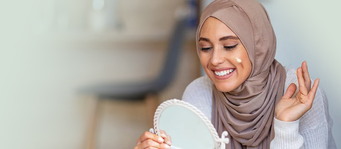 prodigia halal cosmetics article, brown hijabi female applying skincare